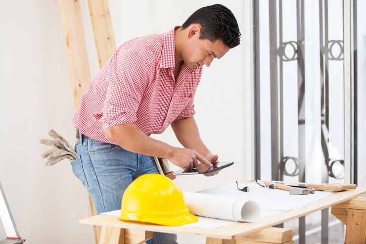 Man planning construction project via iPad